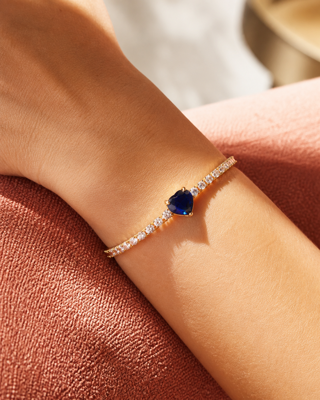 Close-up of a Kessia blue heart crystal bangle on a wrist