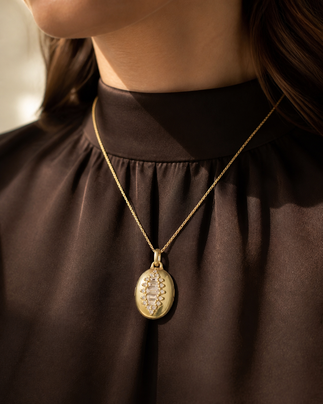Close-up of the Kessia baguette crystal oval locket pendant being worn